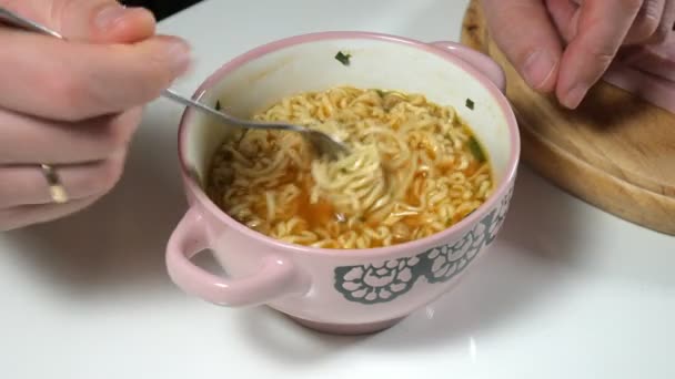 L'uomo sta mangiando spaghetti istantanei cinesi con una forchetta. — Video Stock