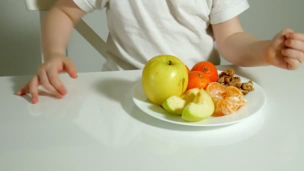 Όμορφη χαριτωμένο μικρό κορίτσι τρώει φρούτα, ευτυχισμένος γκρο πλαν — Αρχείο Βίντεο