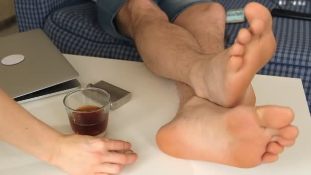 A woman and a man take off the wedding rings and put them on the table. on the table is alcohol, feet of men. close-up — Stock Video