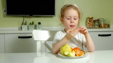 Güzel sevimli küçük kız meyve mutlu yemek