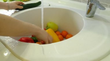 Mutfak lavabo musluk altında taze sebze kadın yıkar