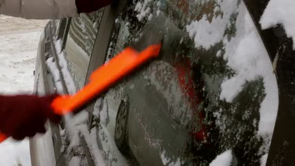 Młoda kobieta czysty samochód po burzy śnieżnej ze zgarniaczem — Wideo stockowe