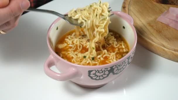 El hombre está comiendo fideos instantáneos chinos con un tenedor — Vídeos de Stock