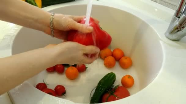 Femme lave les légumes frais sous le robinet dans l'évier dans la cuisine — Video