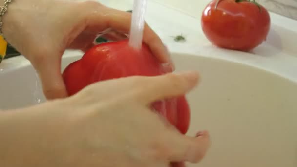 Mujer lava verduras frescas bajo el grifo en el fregadero en la cocina — Vídeo de stock