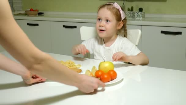 Szép, édes lány megtagadja egy tál gyümölcs, csoki, chips, vesz egy lemezt snack, csokoládé, chips — Stock videók