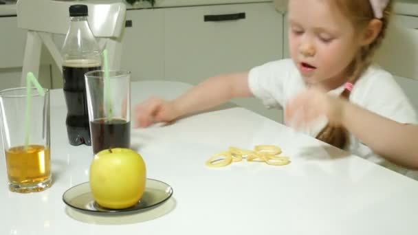 Vacker söt flicka vägrar en tallrik med frukt, choklad, chips, tar en tallrik med snacks, choklad, chips — Stockvideo
