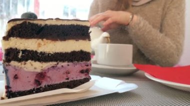 Kafede çay fincan okşayarak yakın çekim el. Restoran sıcak içecek ve pasta kadında