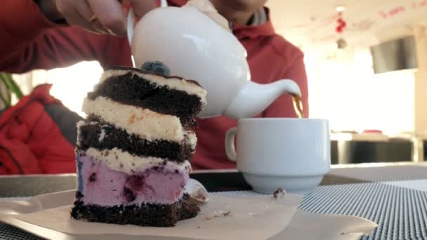 Mão de homem de close-up acariciando a xícara de chá no café. homem em restaurante com bebida quente e bolo — Vídeo de Stock