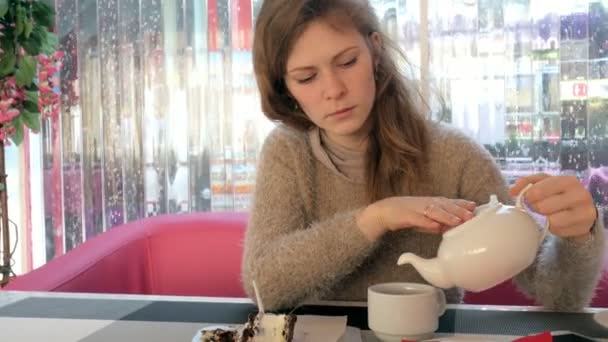Ženská ruka hladila šálek čaje v kavárně. Žena v restauraci s horký nápoj a dort — Stock video