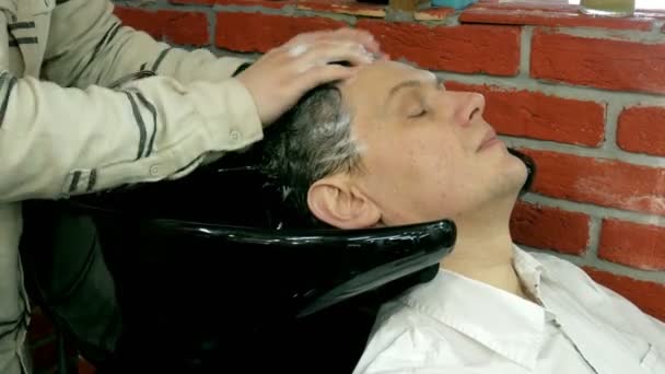 Мужчина моет голову в парикмахерской — стоковое видео