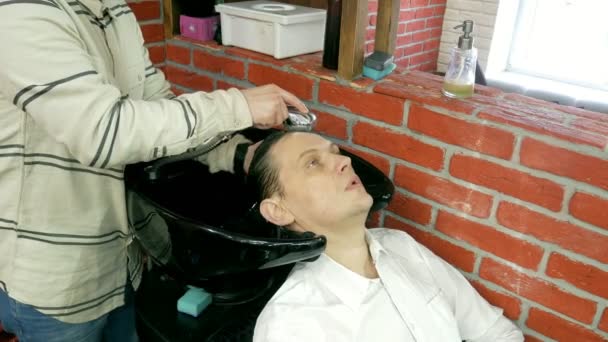 Un homme se lave la tête dans le salon de coiffure — Video