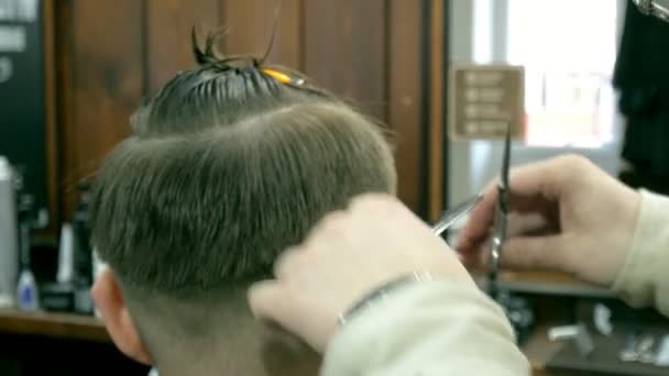 Friseur schneidet dem Kunden mit Schere die Haare — Stockvideo