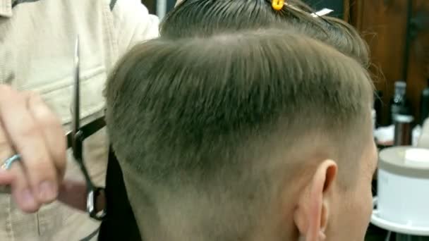 Barber coupe les cheveux du client avec des ciseaux — Video