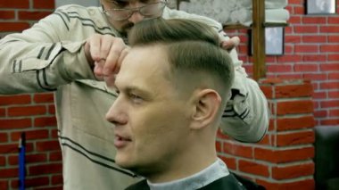 Kuaför Saç istemcinin makas ile keser.