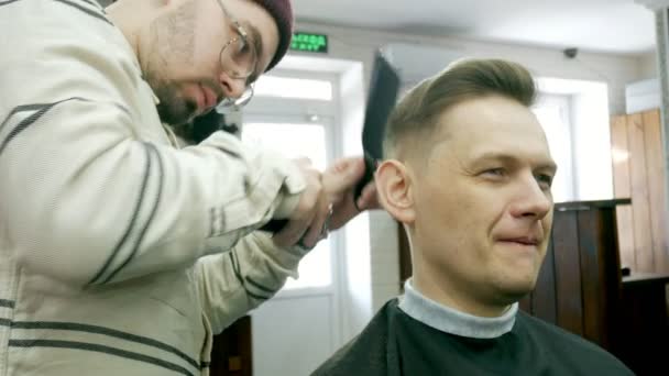 Barbiere taglia i capelli del cliente con le forbici — Video Stock