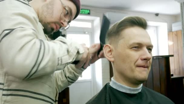 Friseur schneidet dem Kunden mit Schere die Haare — Stockvideo