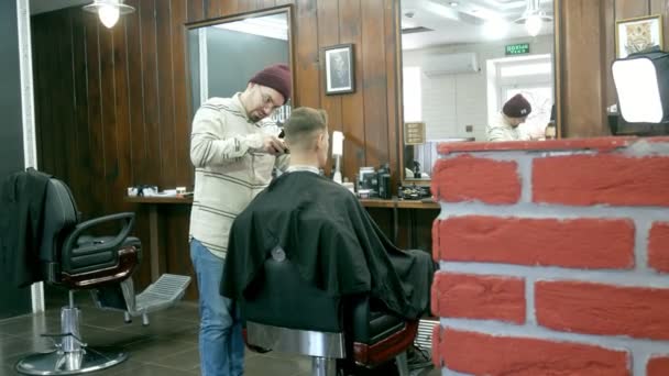 Barber coupe les cheveux du client avec des ciseaux — Video