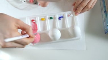 Bir kadın renkli boyalar ile Paskalya yumurtaları boyar yakın çekim