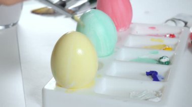 Bir kadın renkli boyalar ile Paskalya yumurtaları boyar yakın çekim