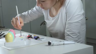 Bir kadın renkli boyalar ile Paskalya yumurtaları boyar yakın çekim