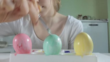 Bir kadın renkli boyalar ile Paskalya yumurtaları boyar yakın çekim