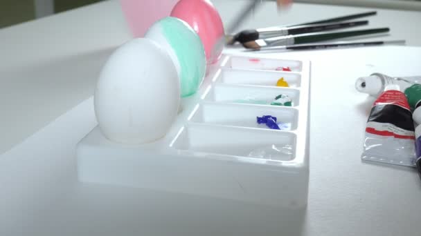 A woman paints Easter eggs with colored paints, close-up — Stock Video