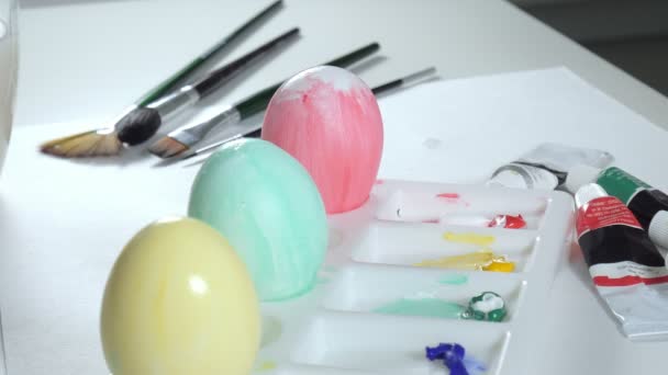 A woman paints Easter eggs with colored paints, close-up — Stock Video