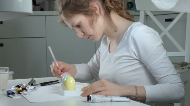 Een vrouw schildert paaseieren met gekleurde verf, close-up — Stockvideo