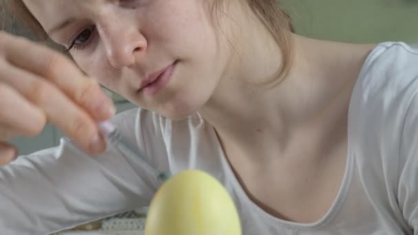 Una donna dipinge uova di Pasqua con vernici colorate, primo piano — Video Stock