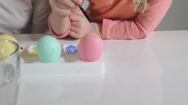 Anne ve kızı Paskalya yumurtaları renkli boya ile çizmek