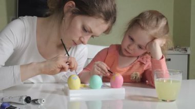 Anne ve kızı Paskalya yumurtaları renkli boya ile çizmek