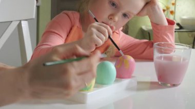 Anne ve kızı Paskalya yumurtaları renkli boya ile çizmek