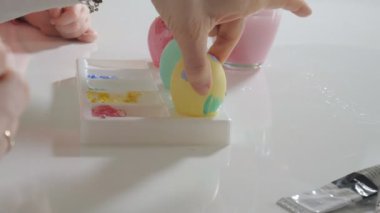 Anne ve kızı Paskalya yumurtaları renkli boya ile çizmek