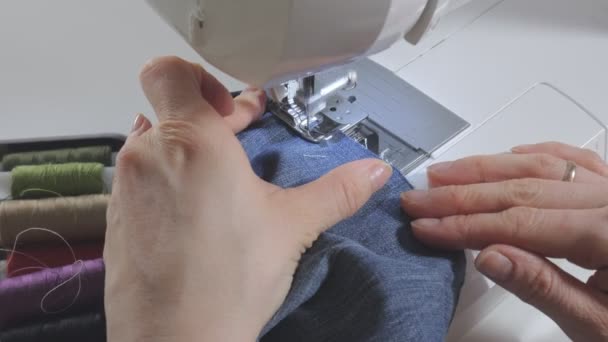 Bir kadın dikiş makinesine dikiş dikiyor. — Stok video