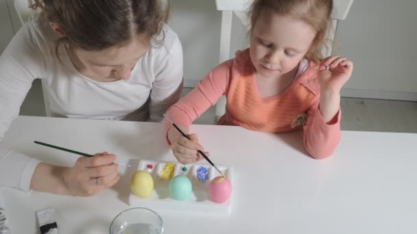 Mother and daughter draw Easter eggs with colored paints — Stock Video