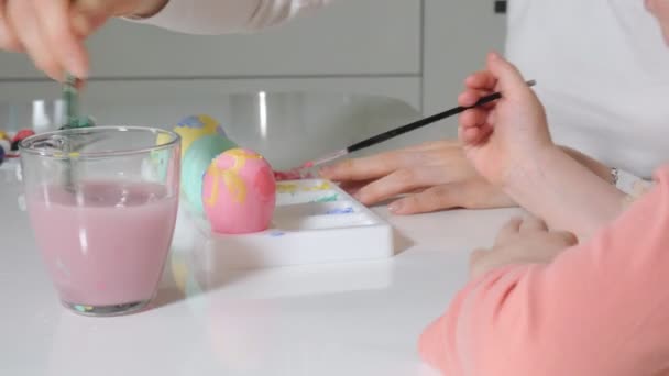 Мать и дочь рисуют пасхальные яйца краской. — стоковое видео