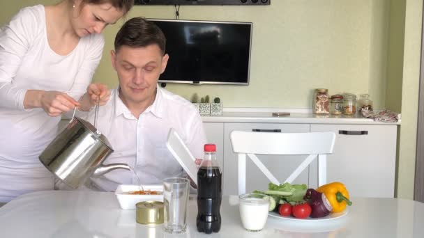 아내와 남편이 중국 국수와 신선한 야채를 먹는 테이블에 앉아 있다. 적절 한 영양 섭취와 건강 한 라이프 스타일의 개념 — 비디오