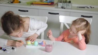 Anne ve kızı Paskalya yumurtaları renkli boya ile çizmek