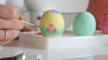 Anne ve kızı Paskalya yumurtaları renkli boya ile çizmek