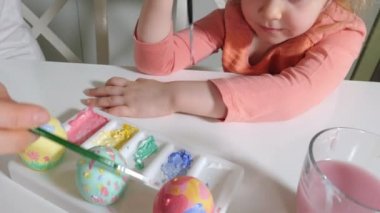 Anne ve kızı Paskalya yumurtaları renkli boya ile çizmek