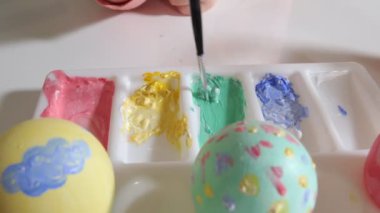 Anne ve kızı Paskalya yumurtaları renkli boya ile çizmek