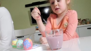 Anne ve kızı Paskalya yumurtaları renkli boya ile çizmek