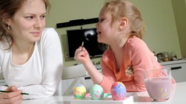 Anne ve kızı Paskalya yumurtaları renkli boya ile çizmek