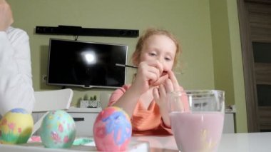 Anne ve kızı Paskalya yumurtaları renkli boya ile çizmek