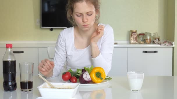 Женщина сидит за столом и ест китайскую лапшу и свежие овощи — стоковое видео