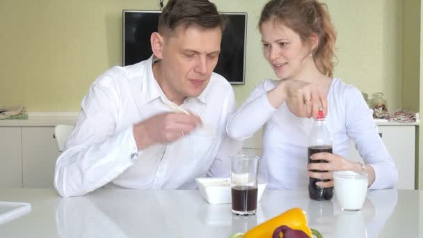 Una esposa y un marido están sentados en una mesa comiendo fideos chinos y verduras frescas. El concepto de nutrición adecuada y estilo de vida saludable — Vídeos de Stock