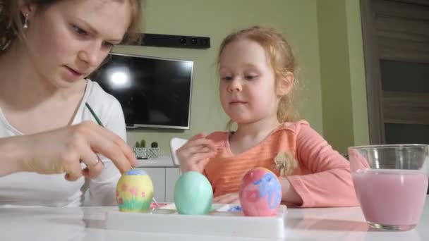 母と娘は、イースターの卵を着色されたペンキを描画します。 — ストック動画