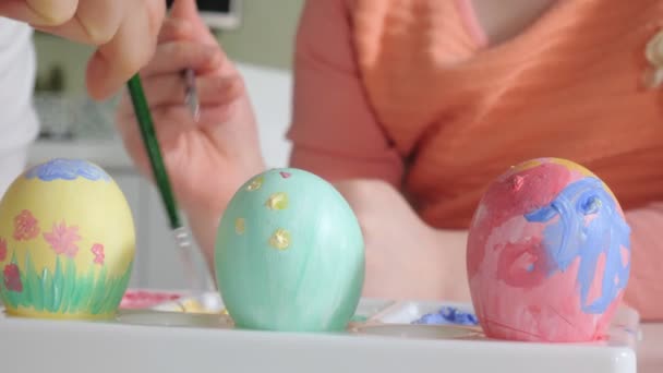Mutter und Tochter malen Ostereier mit bunten Farben — Stockvideo