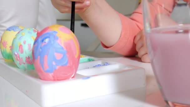 Moeder en dochter tekenen paaseieren met gekleurde verven — Stockvideo